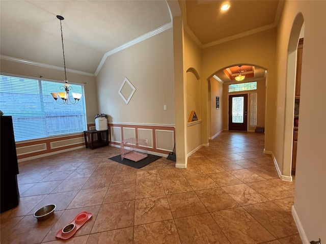 interior space featuring crown molding, arched walkways, baseboards, and a notable chandelier