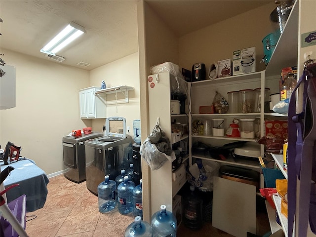 storage area with separate washer and dryer and visible vents