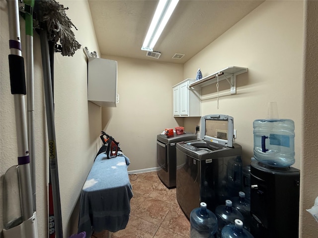 laundry room with cabinet space, washing machine and dryer, and visible vents