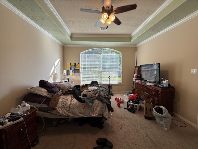 carpeted bedroom featuring a ceiling fan, a raised ceiling, ornamental molding, and visible vents