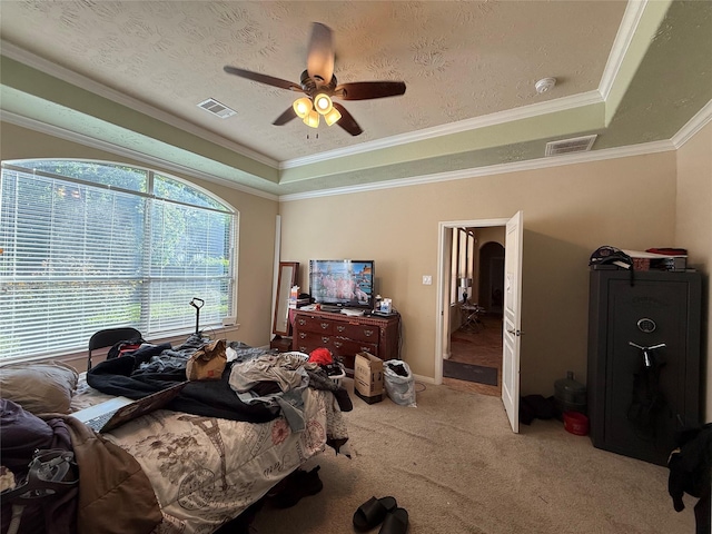 bedroom featuring light colored carpet, a raised ceiling, crown molding, and visible vents