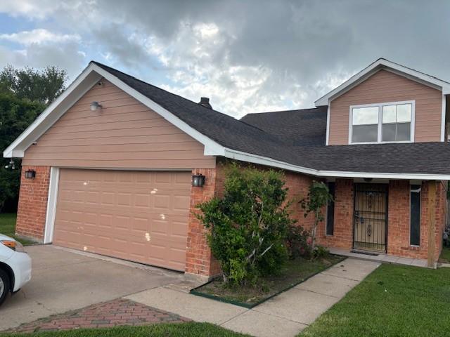 view of front of house featuring driveway, brick siding, and a garage