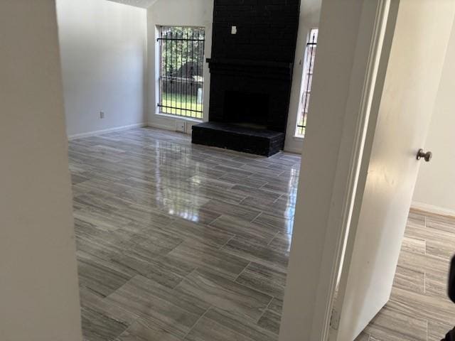 unfurnished living room featuring a fireplace and baseboards