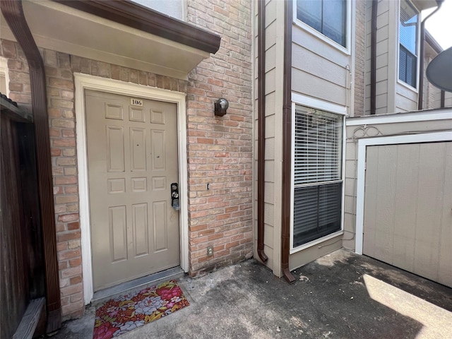 doorway to property featuring brick siding