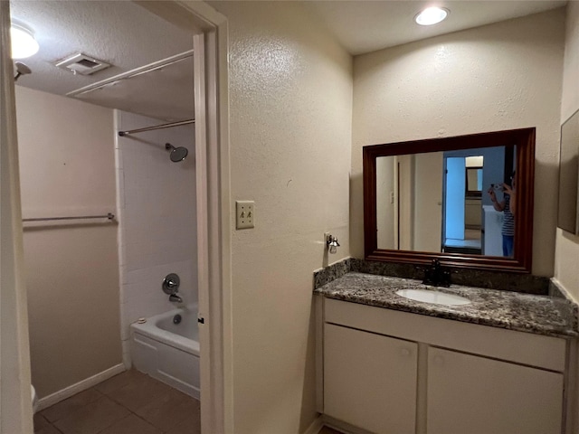 bathroom with shower / bathing tub combination, vanity, visible vents, tile patterned floors, and baseboards