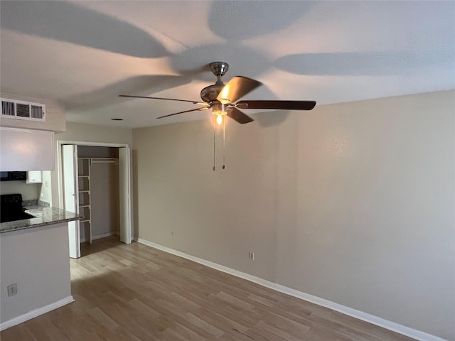 interior space featuring a ceiling fan, baseboards, visible vents, and wood finished floors