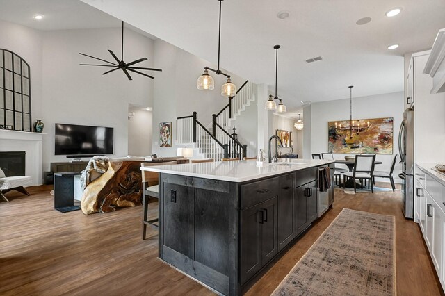 kitchen featuring a sink, open floor plan, visible vents, light countertops, and appliances with stainless steel finishes