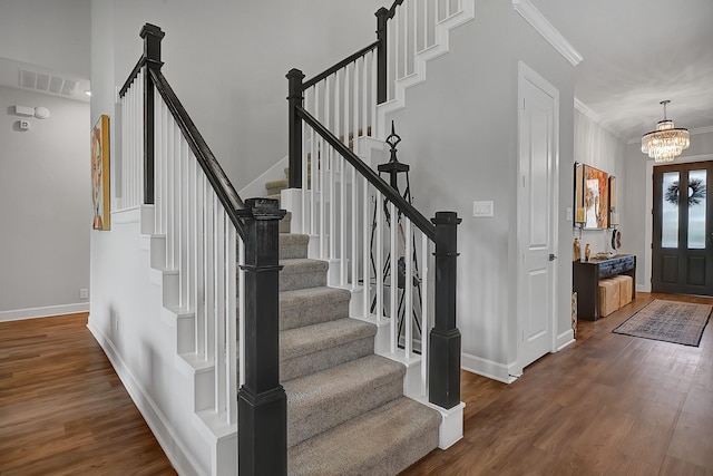 entryway featuring ornamental molding, stairs, visible vents, and wood finished floors
