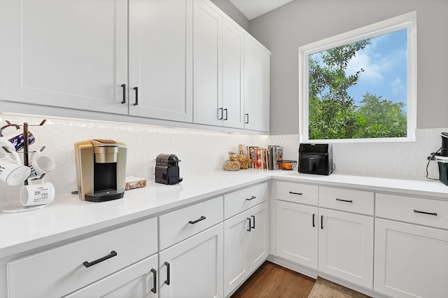kitchen featuring white cabinetry, backsplash, light countertops, and dark wood-style floors
