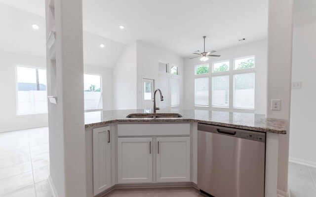23403 Malbec Dr, Alvin, TX 77511 - kitchen featuring stainless steel dishwasher, a sink, light stone countertops, ceiling fan, and baseboards