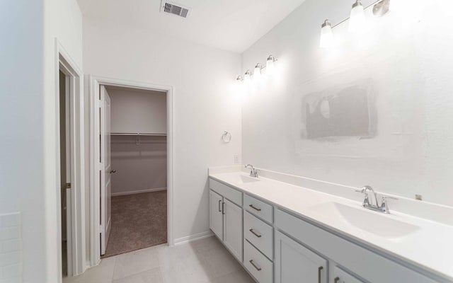 23403 Malbec Dr, Alvin, TX 77511 - full bathroom featuring double vanity, tile patterned flooring, a walk in closet, and baseboards