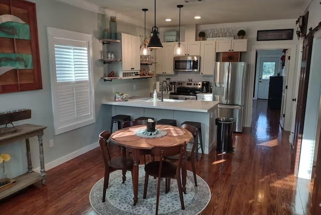 kitchen with baseboards, dark wood-style flooring, a peninsula, open shelves, and stainless steel appliances