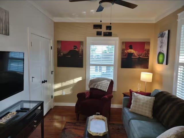 living area featuring ceiling fan, ornamental molding, baseboards, and wood finished floors