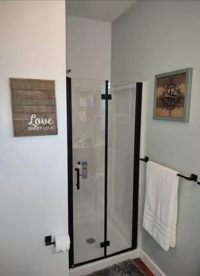 full bath with baseboards and a stall shower