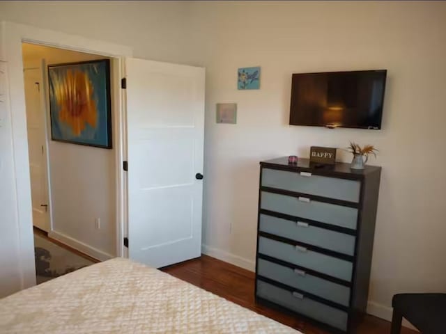 bedroom with dark wood-style flooring and baseboards