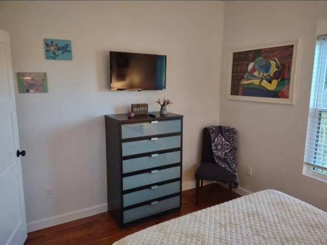 bedroom featuring baseboards and dark wood finished floors
