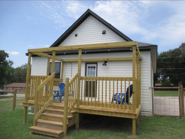 rear view of property with a yard and a wooden deck