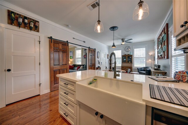 704 Burleson St, Brenham, TX 77833 - kitchen with open floor plan, a barn door, ornamental molding, pendant lighting, and light countertops