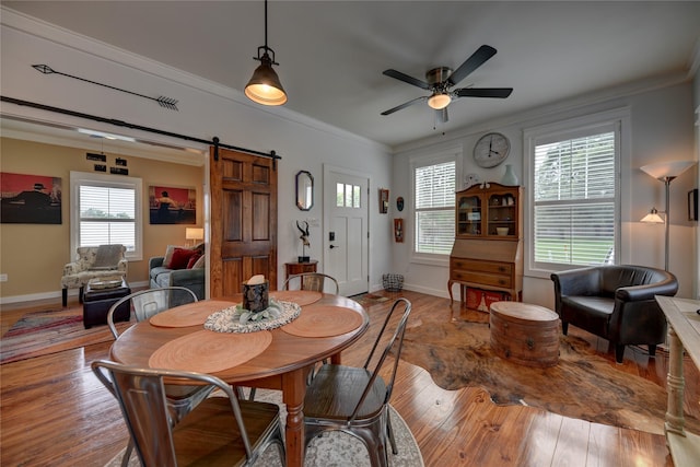 704 Burleson St, Brenham, TX 77833 - dining room with a barn door, a ceiling fan, wood-type flooring, and crown molding