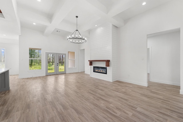 679 Rd 66111, Dayton, TX 77535 - unfurnished living room featuring recessed lighting, baseboards, a towering ceiling, beamed ceiling, and light wood-type flooring