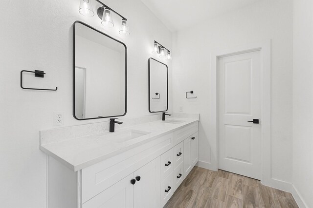 679 Rd 66111, Dayton, TX 77535 - bathroom with baseboards, double vanity, a sink, and wood finished floors