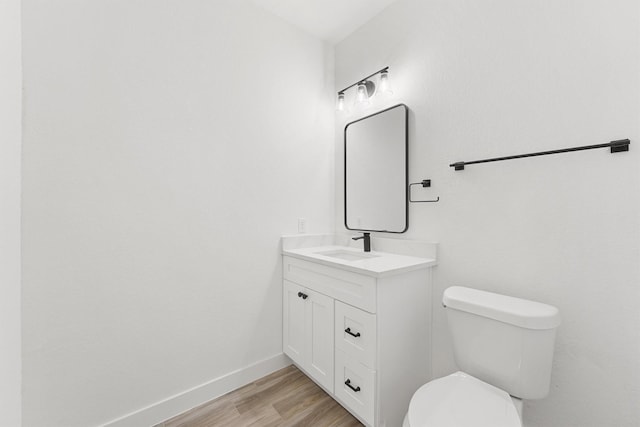 679 Rd 66111, Dayton, TX 77535 - bathroom featuring toilet, baseboards, wood finished floors, and vanity