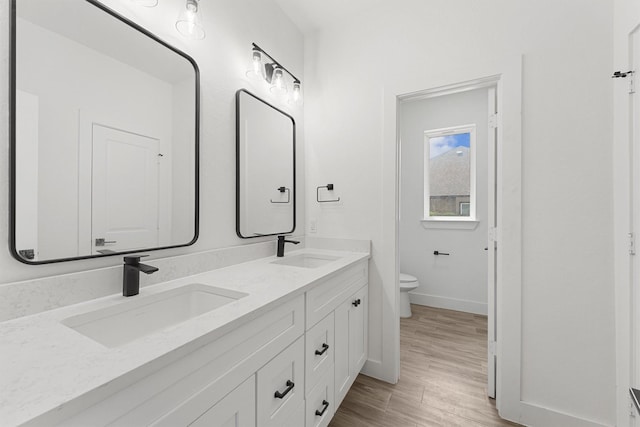 679 Rd 66111, Dayton, TX 77535 - bathroom featuring toilet, baseboards, double vanity, and a sink
