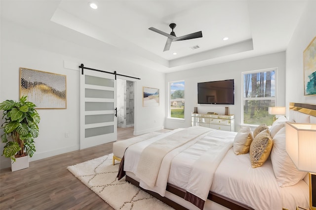 679 Rd 66111, Dayton, TX 77535 - bedroom with wood finished floors, visible vents, baseboards, a barn door, and a raised ceiling