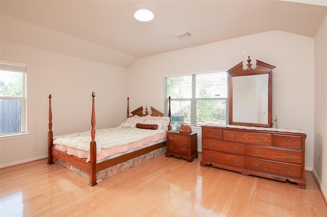 bedroom with lofted ceiling, light wood-style flooring, visible vents, and multiple windows