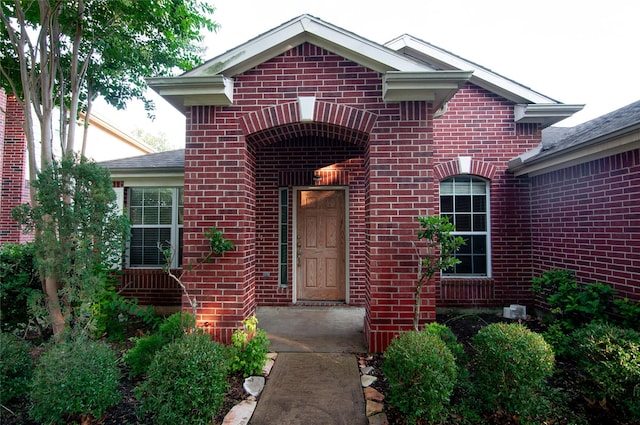 property entrance featuring brick siding