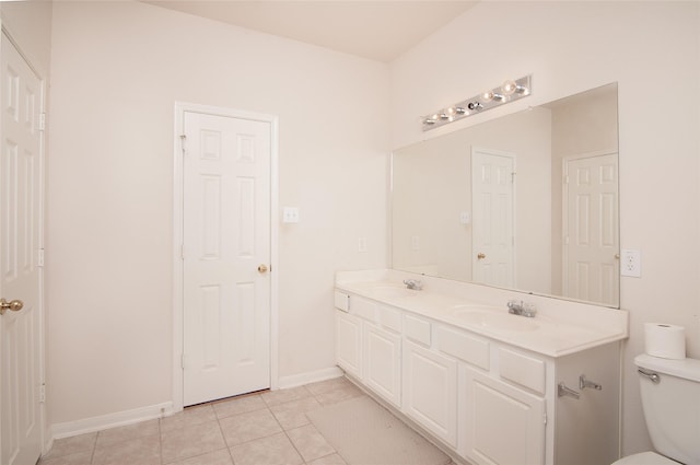 full bathroom featuring double vanity, toilet, tile patterned flooring, and a sink