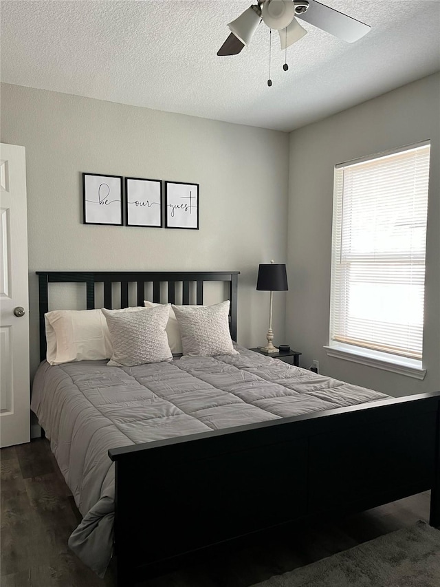 5410 Bataan Rd, Houston, TX 77033 - bedroom featuring dark wood-style flooring, a ceiling fan, and a textured ceiling