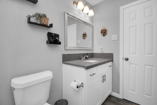 5410 Bataan Rd, Houston, TX 77033 - bathroom featuring vanity, toilet, wood finished floors, and baseboards