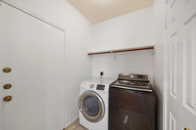 laundry room featuring laundry area, light tile patterned floors, and washing machine and dryer