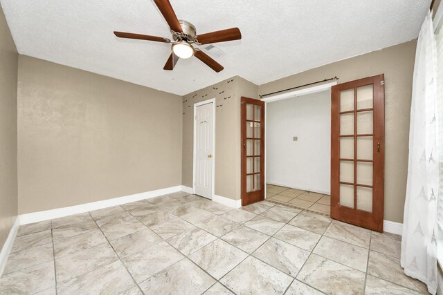 unfurnished room featuring french doors, light tile patterned floors, ceiling fan, a textured ceiling, and baseboards