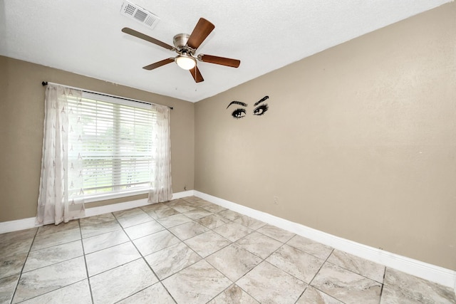 empty room with a ceiling fan, baseboards, and light tile patterned flooring