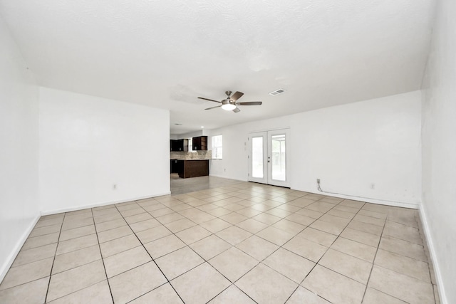 unfurnished living room featuring ceiling fan, baseboards, and light tile patterned flooring
