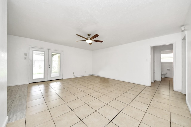 unfurnished room featuring ceiling fan, french doors, and light tile patterned floors