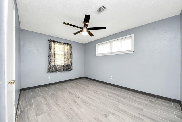 unfurnished room with a ceiling fan, baseboards, and light wood-style flooring
