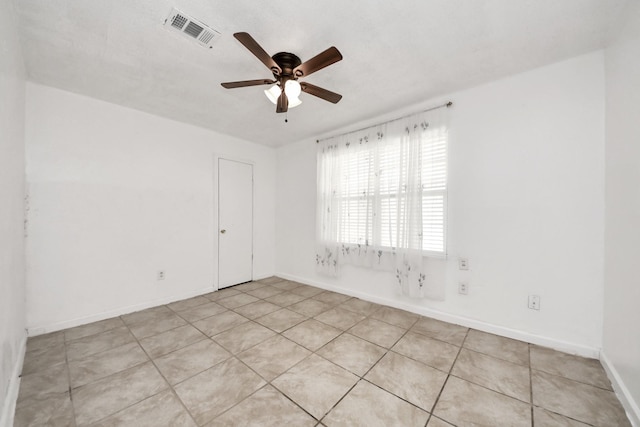 empty room with a ceiling fan and baseboards