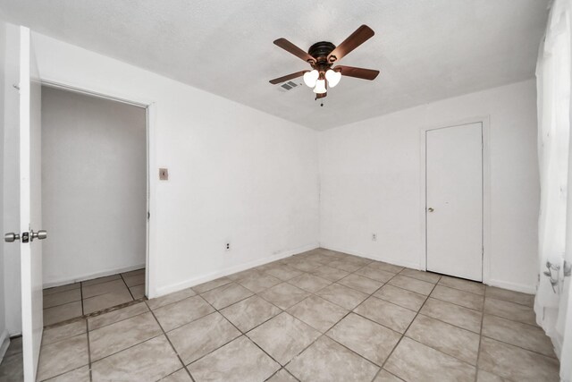 spare room featuring ceiling fan and light tile patterned floors