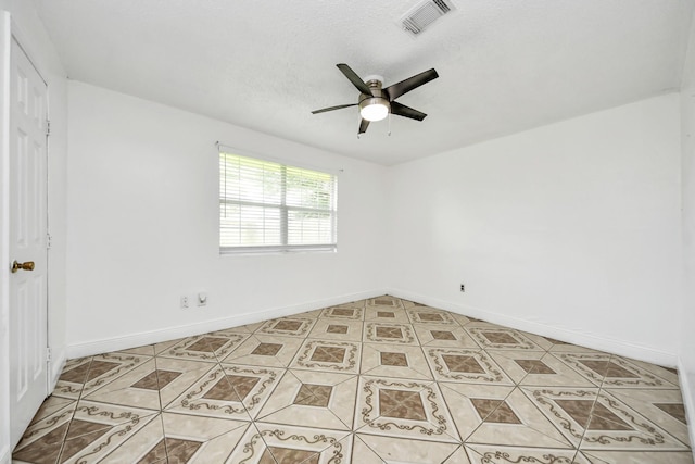 empty room with ceiling fan, baseboards, and light tile patterned floors