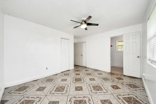 unfurnished bedroom featuring light tile patterned floors, baseboards, and ceiling fan