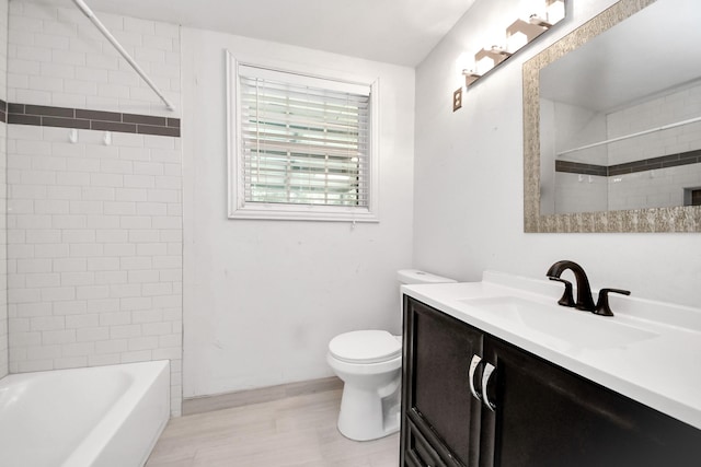 full bath with toilet, wood finished floors, vanity, and bathing tub / shower combination