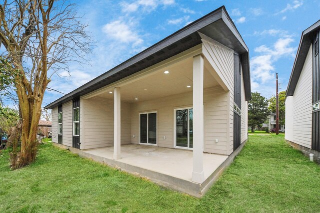 back of house featuring a patio and a lawn