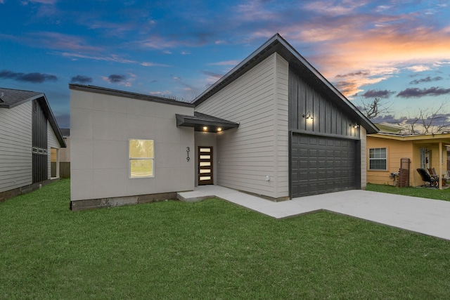 contemporary home featuring driveway, a garage, a front yard, and board and batten siding