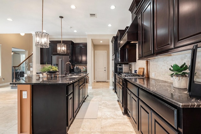 kitchen featuring a sink, dark stone countertops, visible vents, a chandelier, and baseboards