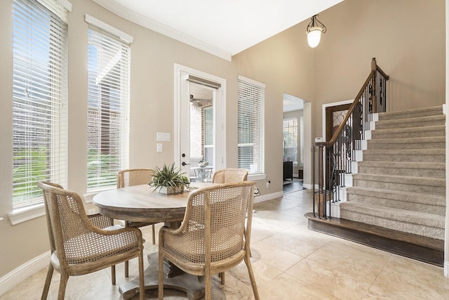 dining area featuring baseboards, stairs, and a healthy amount of sunlight