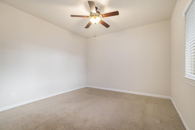 spare room featuring baseboards, ceiling fan, and light colored carpet