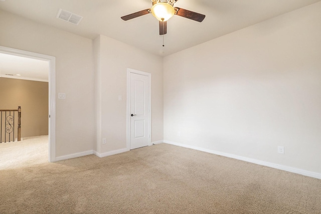 spare room featuring light colored carpet, ceiling fan, and visible vents